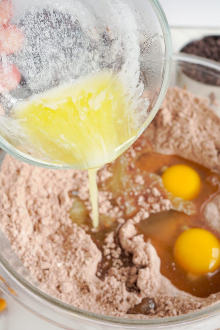 Candy Bar Brownie Cookies adding eggs and butter into bowl