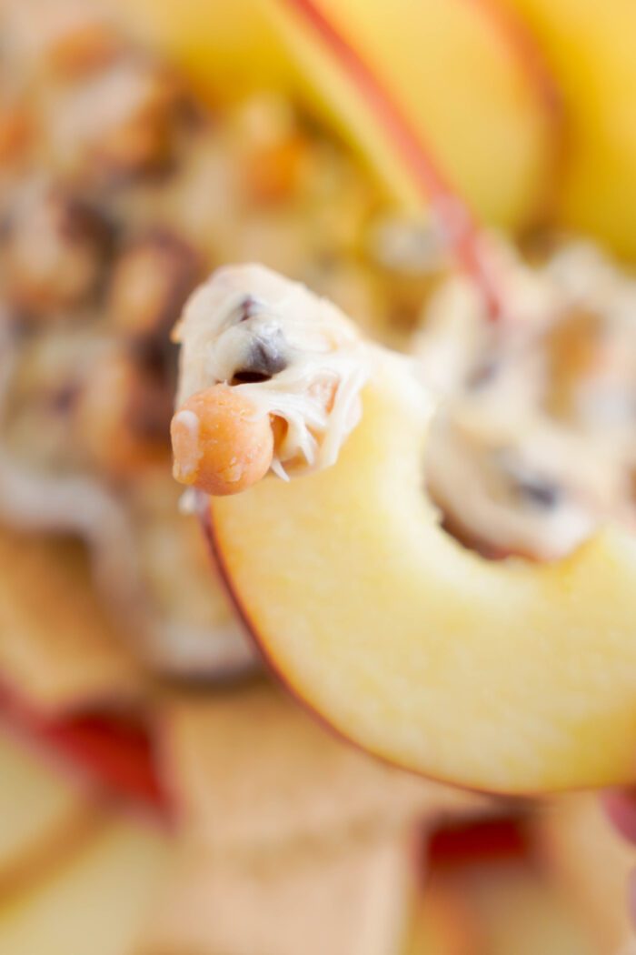 Snickers Dip being dipped with apple slice