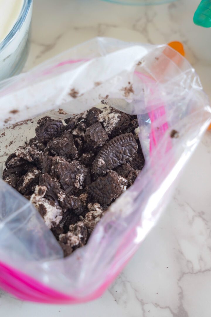 Oreo Dirt Pudding Cheesecake Bars with crushed Oreo in bag