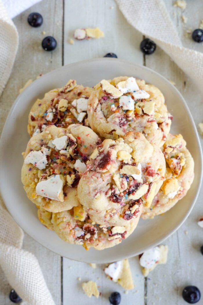 A plate of colorful cookies with blueberries.