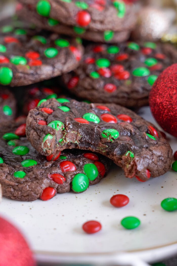 Christmas M&M Cookies propped up on another cookie with a bite taken out