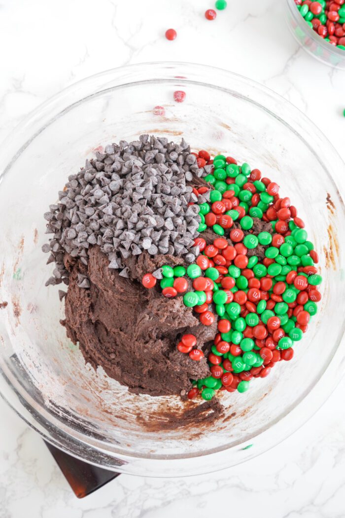 Christmas M&M Chocolate Brownie Cookies adding chocolate chips and M&Ms