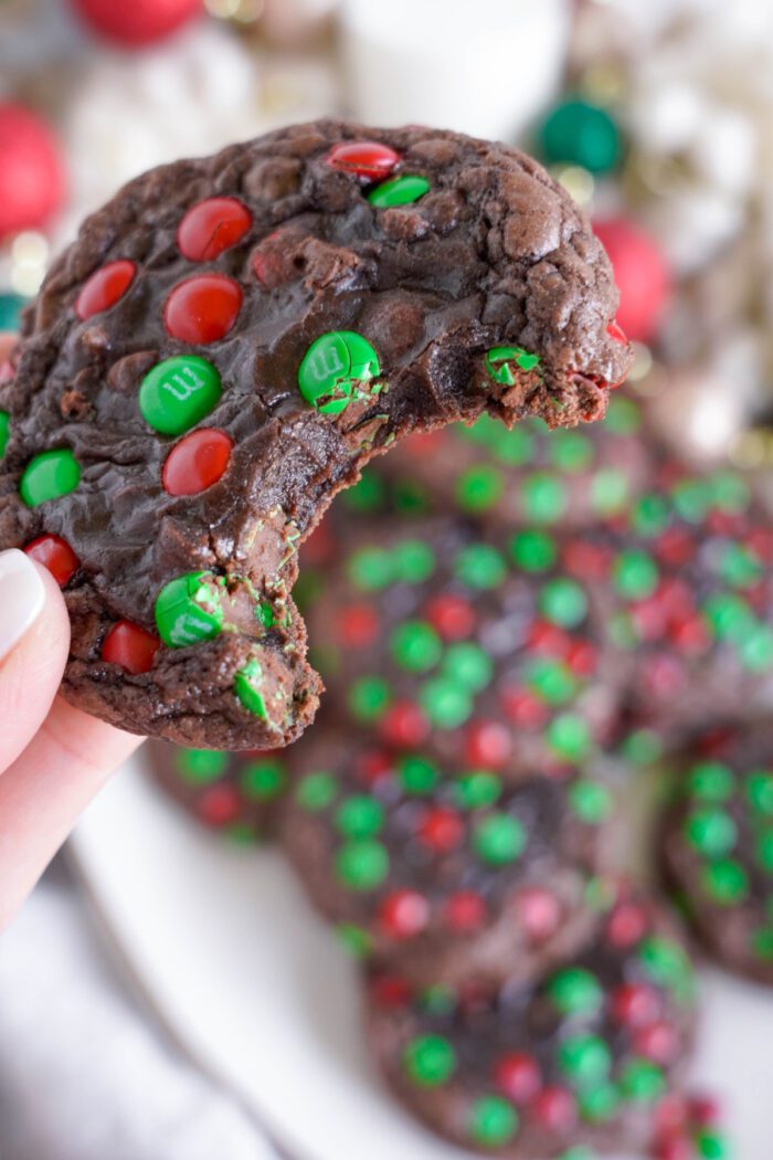 Brownie Christmas Cookies being held by someone with bite taken out