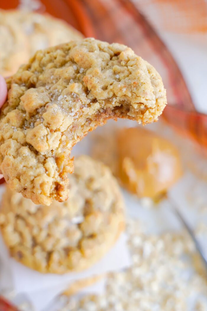 A close-up of a bitten oatmeal cookie.