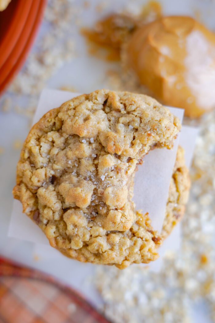 A close-up image of a bitten oatmeal cookie.