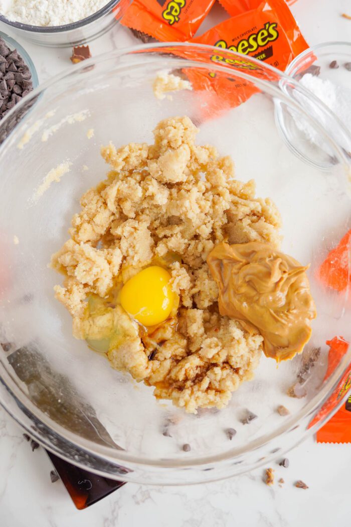 Reese's Stuffed Chocolate Chip Cookies adding egg, vanilla, and peanut butter