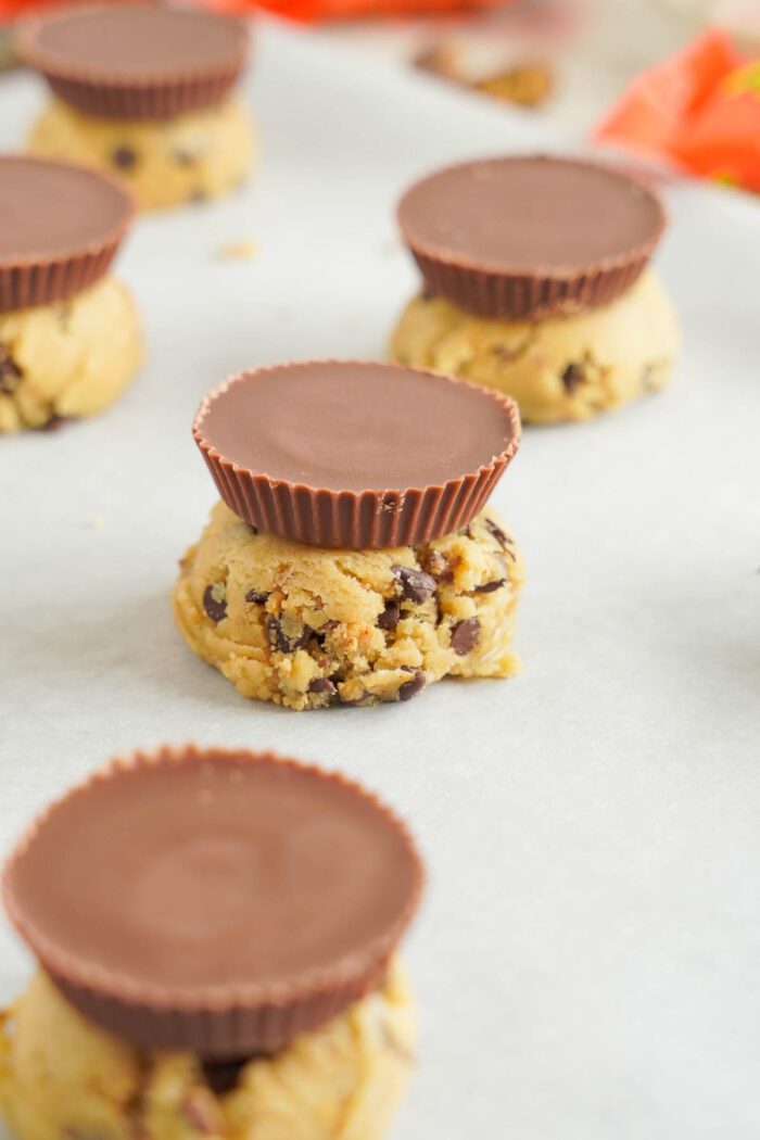 Reese's Stuffed Chocolate Chip Cookies dough balls topped with Reese's cups