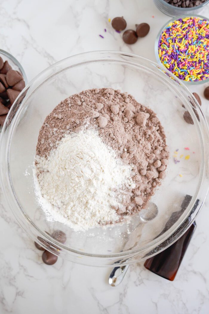 A bowl of ingredients for easy brownie cookies with sprinkles and chocolate chips for Easter.