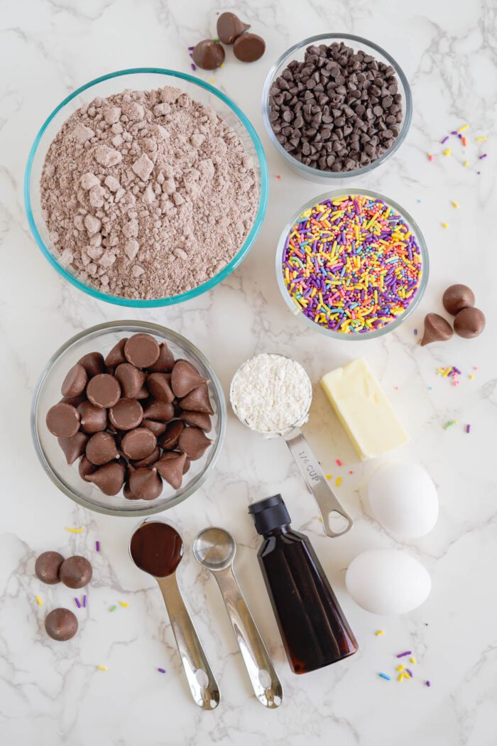 Chocolate cake ingredients for Easy Brownie Cookies on a marble table.