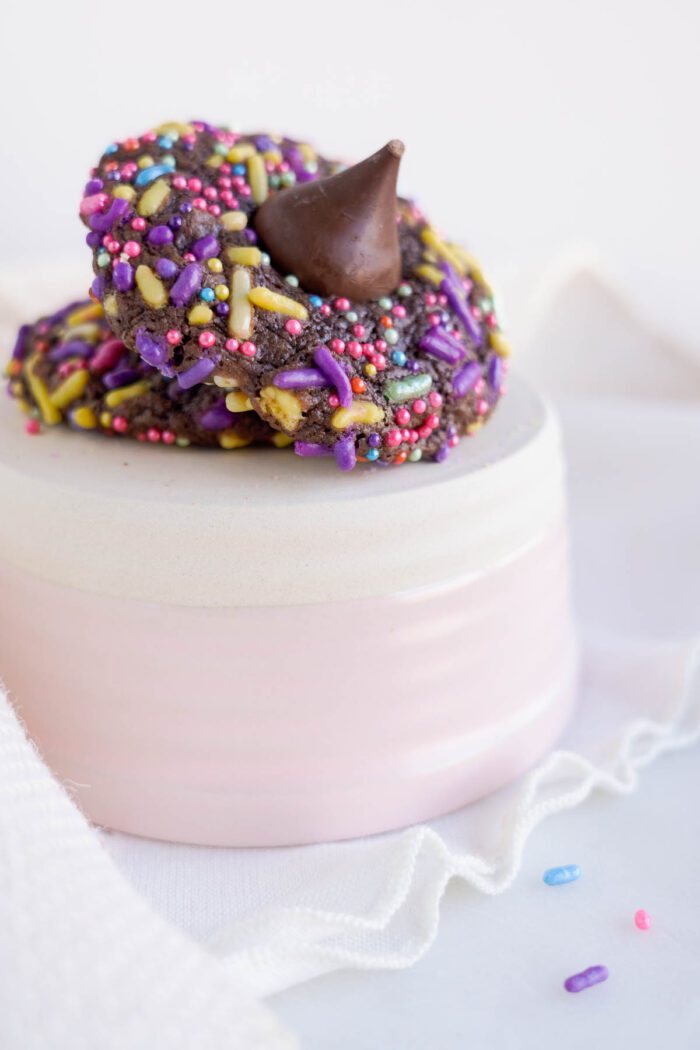 Chocolate donuts with sprinkles on top of a white plate for Easter.