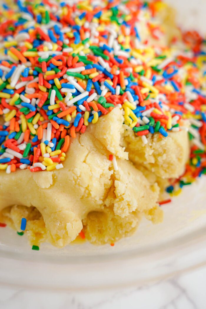 Cookie dough with colorful sprinkles on top.