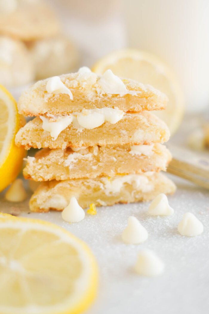 Stack of Lemon White Chocolate Chip Cookies, accompanied by fresh lemon slices.