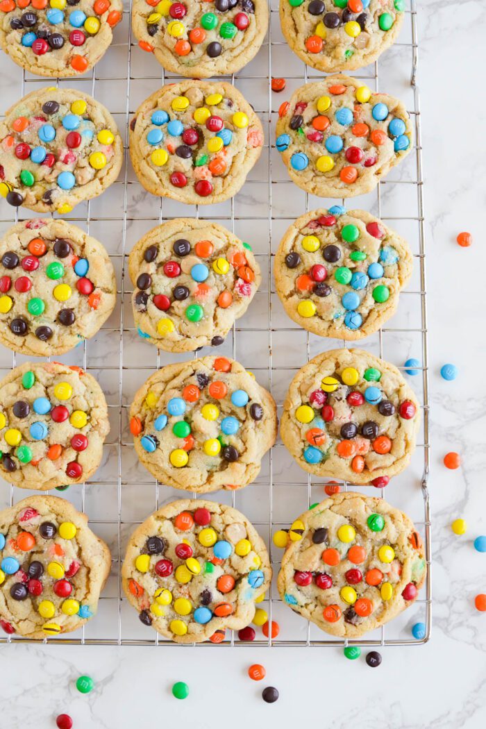 A wire rack with colorful M&M cookies.