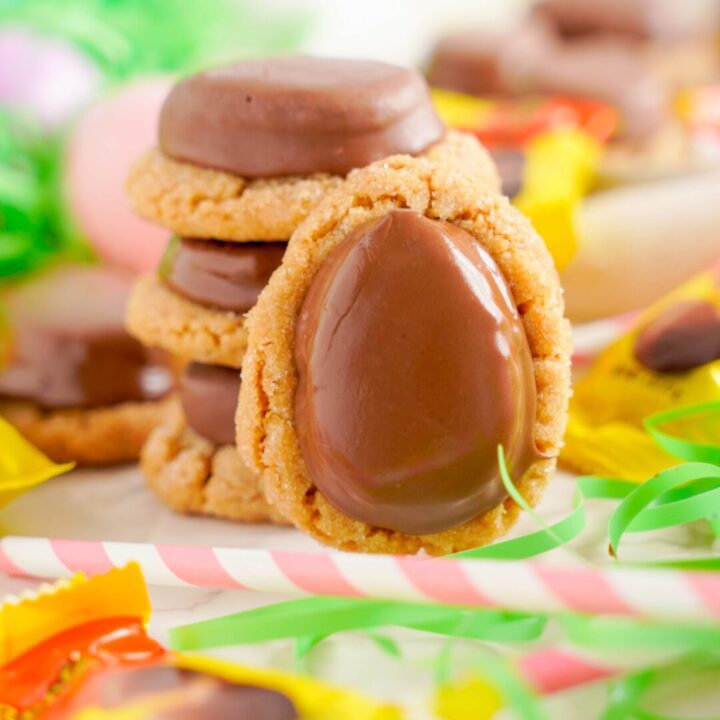 A stack of Reese's Egg Peanut Butter Cookies surrounded by colorful Easter candy.
