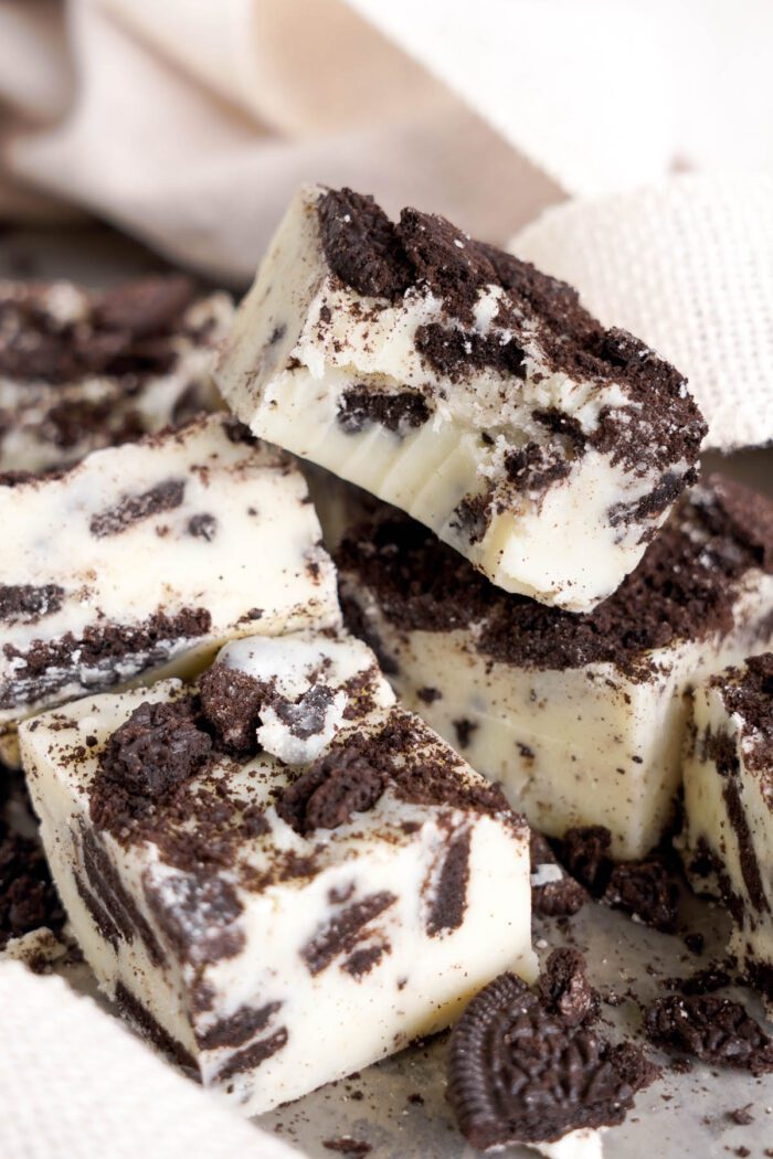 Chunks of Oreo fudge on a beige surface.