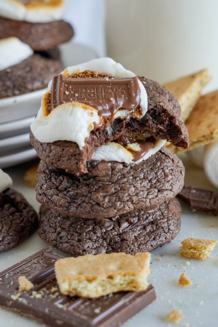 A stack of chocolate S'mores cookies with marshmallows and chocolate bars.