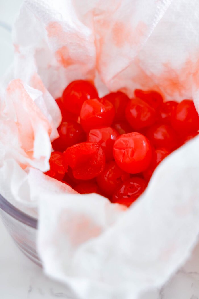 A bowl of cherry chocolate chip cookies wrapped in a paper towel.