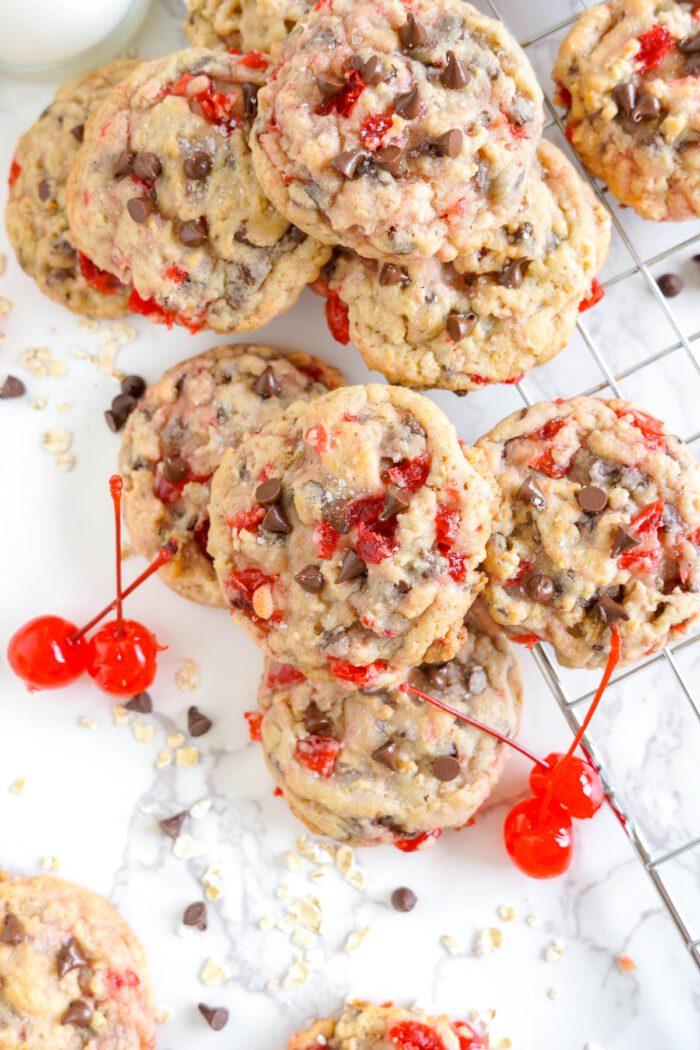 A pile of cherry chocolate chip cookies on a table.