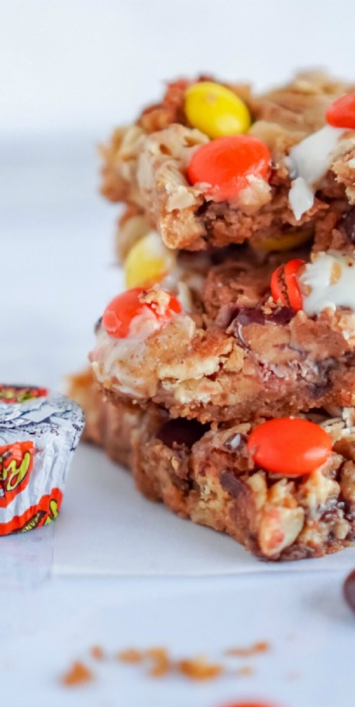 Stack of homemade Peanut Butter Magic Bars bars with colorful candies.