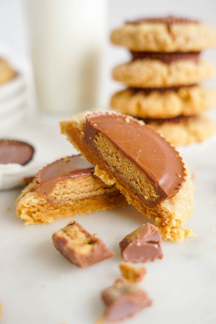 A close-up image of a stack of two halves of a peanut butter cookie with chocolate filling.