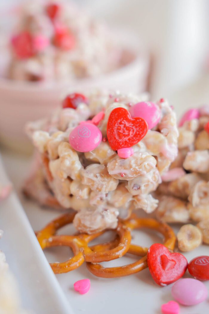 Close-up of a valentine's day themed snack with pretzels, garnished with pink and red heart-shaped candies.