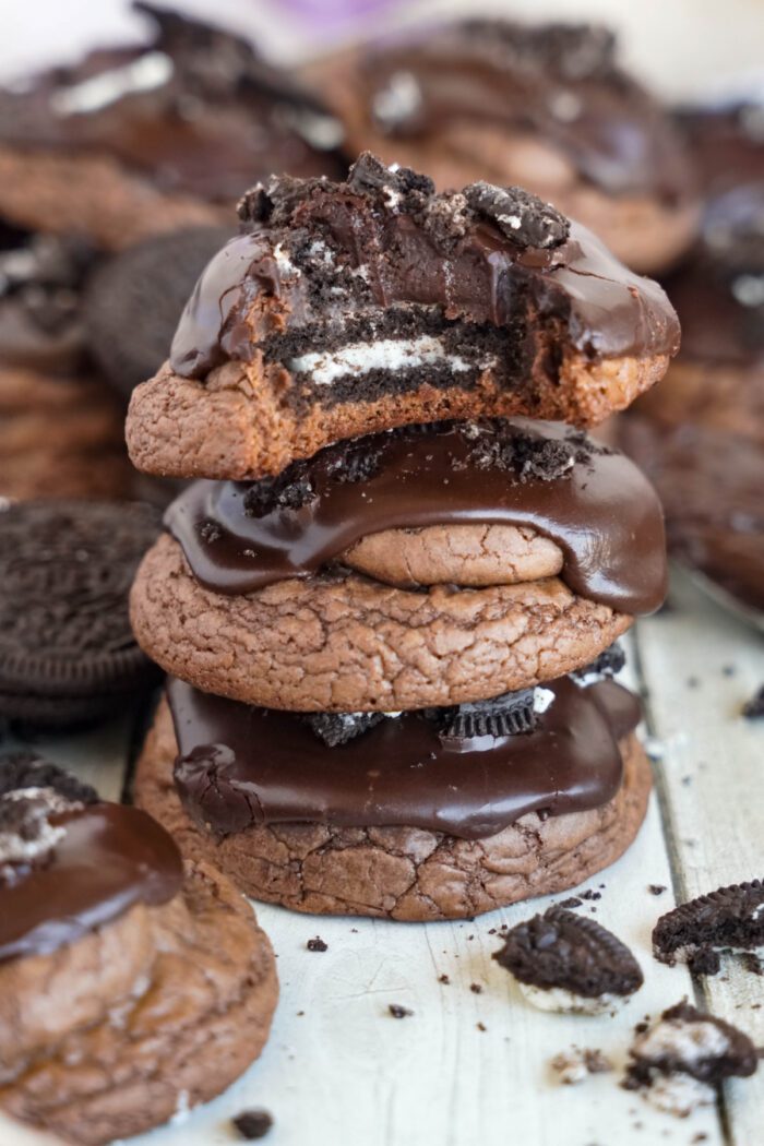 Oreo Stuffed Brownie Cookies stacked with a bite taken out of the top cookie