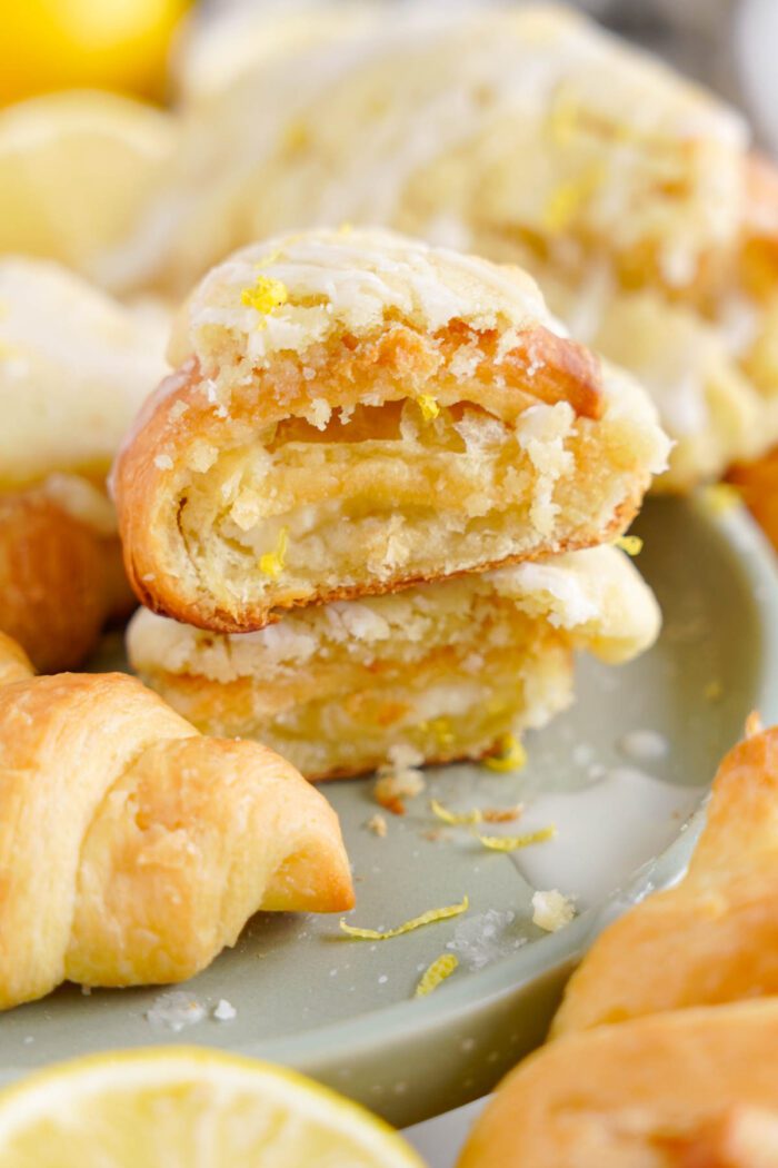 A stack of flaky lemon crookies on a plate, with lemon zest sprinkled on top.